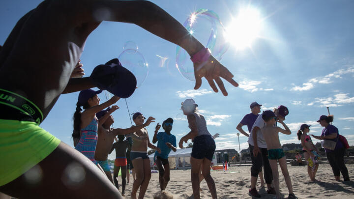 Children play on Deauville beach in northwestern France on August 24, 2022, as part of the "Days of the Forgotten of the Holidays" campaign organised by French NGO Secours Populaire.