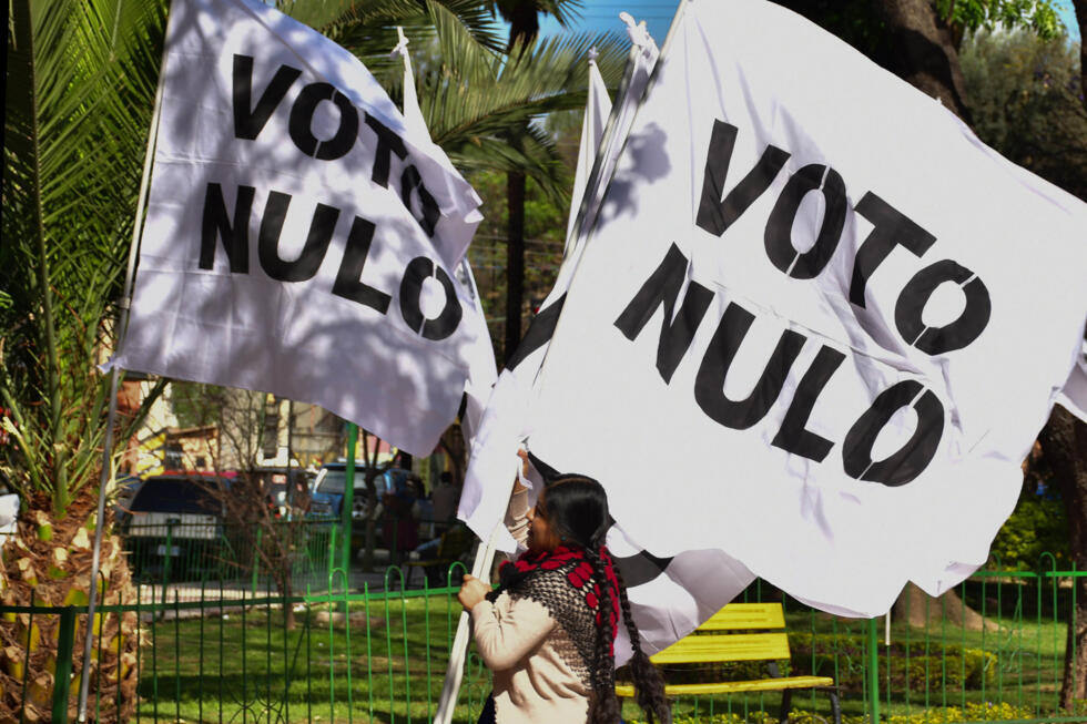 Una seguidora del expresidente de Bolivia Evo Morales, sostiene una bandera durante una campaña por el voto nulo este viernes, en Cochabamba, Bolivia. Morales aseguró que el voto nulo no será el que le abra "las puertas a la derecha" en las elecciones generales del 17 de agosto.