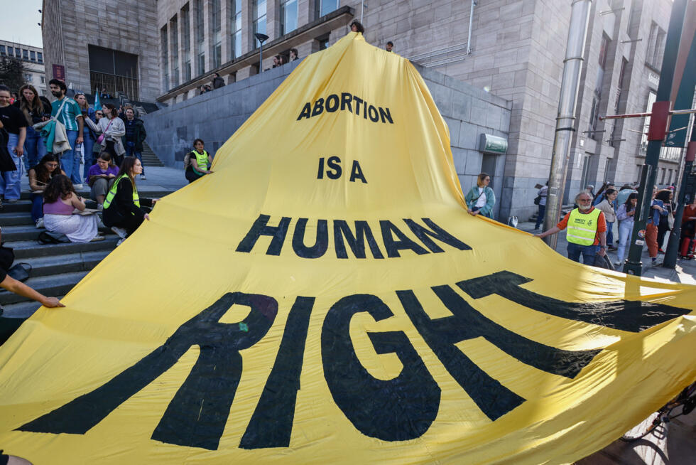 Une banderole sur laquelle on peut lire "L'avortement est un droit humain" avant une manifestation marquant la Journée internationale des femmes à Bruxelles, le 8 mars 2025
