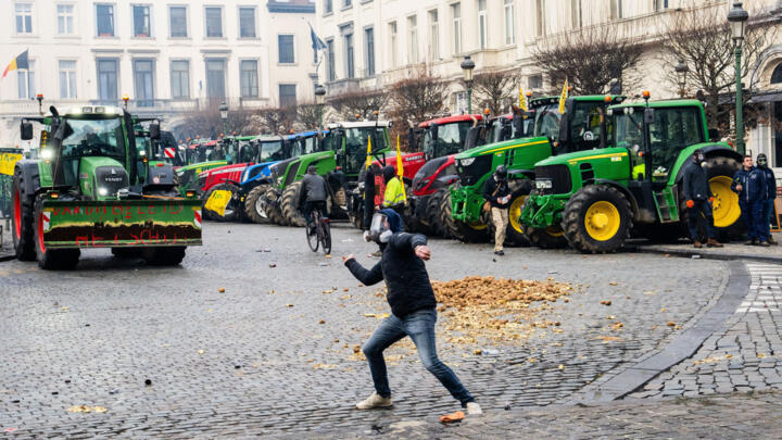 Un agriculteur lance une pomme de terre lors d'une manifestation des agriculteurs européens, le 18 décembre 2025, à Bruxelles.