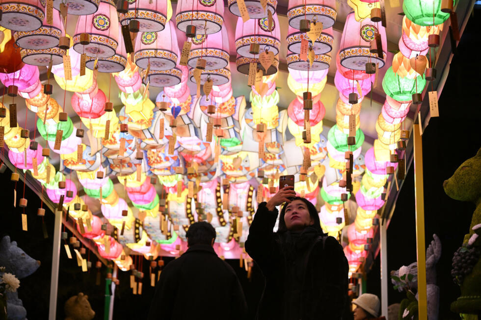 Een vrouw maakt een foto onder lantaarns met nieuwjaarswensen van boeddhistische volgelingen in de Jogyesa-tempel in het centrum van Seoul op 31 december 2025