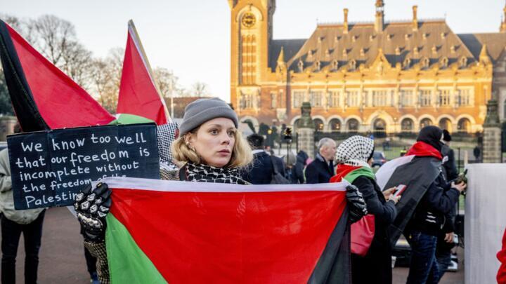 A protester holds a Palestinian flag during a demonstration outside the International Court of Justice (ICJ) as hearings open in South Africa's case against Israel in the Hague, Netherlands on January 11, 2024.