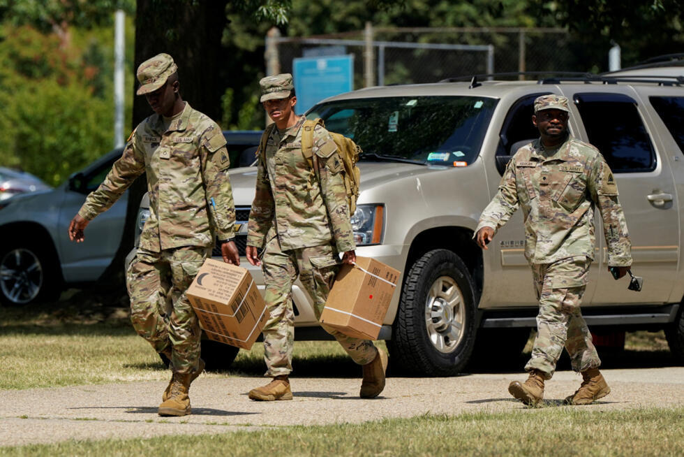 Personal militar estadounidense camina con cajas de comidas listas para comer (MRE) afuera del Arsenal de Washington D.C. tras el anuncio del presidente Donald Trump de desplegar la Guardia Nacional y federalizar el Departamento de Policía Metropolitana en Washington, D.C., EE. UU., el 12 de agosto de 2025.
