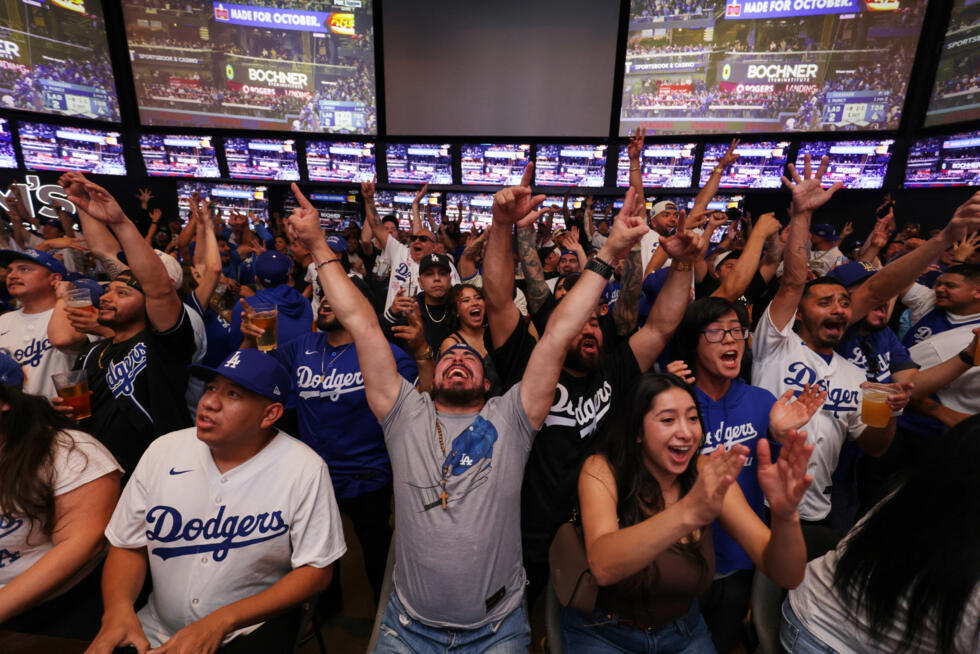 Fanáticos de los Dodgers celebran mientras siguen la transmisión del séptimo juego de la Serie Mundial entre su equipo y los Azulejos de Toronto. Los Ángeles, 1 de noviembre de 2025.