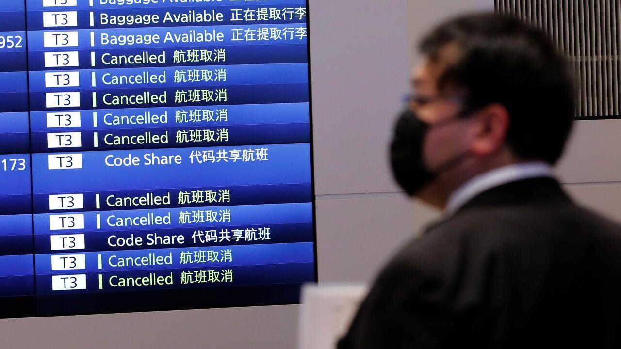 Un hombre frente a un monitor que muestra los horarios de los vuelos en una sala de llegadas de la terminal internacional del aeropuerto de Haneda, en medio de la propagación por varios países de la nueva variante del Covid-19, ‘Ómicron’. En Tokio, Japón, el 29 de noviembre de 2021.