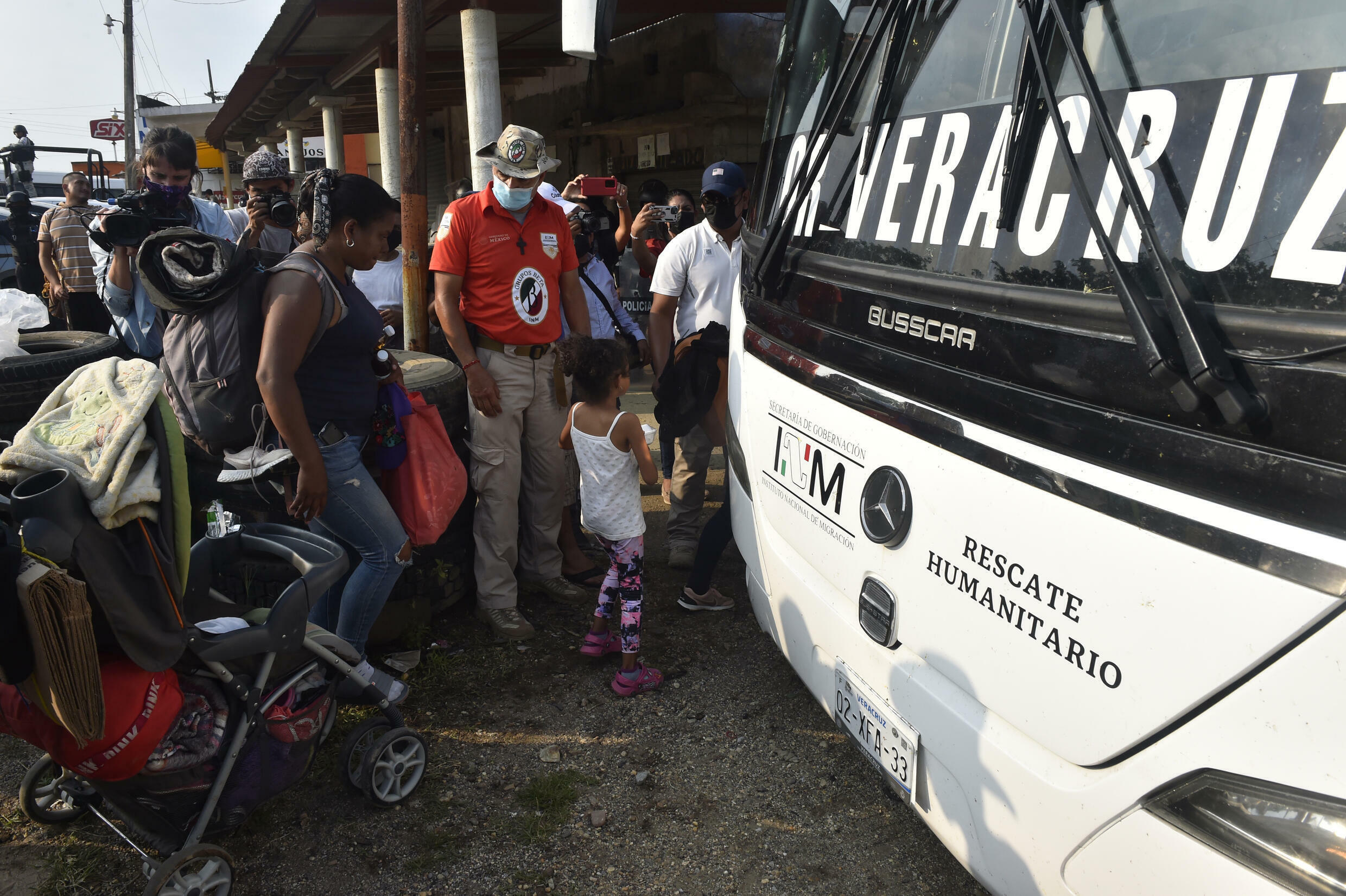 Migrants traveling in a caravan board a bus after accepting an offer from the Mexican authorities of a one-year residency permit on humanitarian grounds