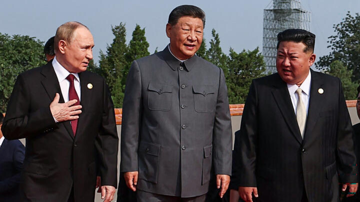 Russia's President Vladimir Putin (L) walks with China's President Xi Jinping and North Korea's leader Kim Jong Un before a military parade marking the 80th anniversary of victory over Japan and the e