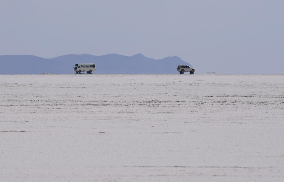 Vehicles drive along a stretch of the Uyuni salt flat on the outskirts of Llipi, Bolivia, on December 15, 2023.