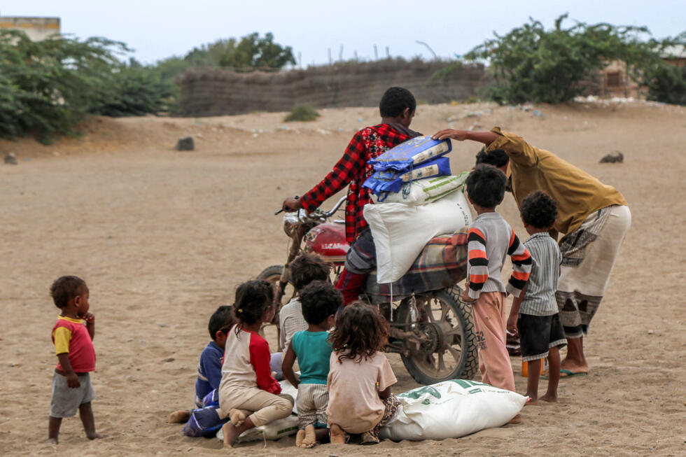Un Yéménite empile à l'arrière d'une moto des colis d'aide humanitaire fournis par des organisations caritatives koweïtiennes aux déplacés par la guerre au Yémen, dans la région de Hays dans la province occidentale de Hodeida, le 9 mars 2025