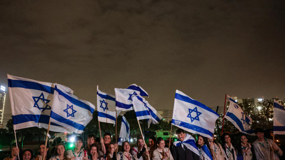 Israeli scouts wave flags of Israel next to the Schneider Hospital as they wait for the release of hostages in Petah Tikva near Tel Aviv