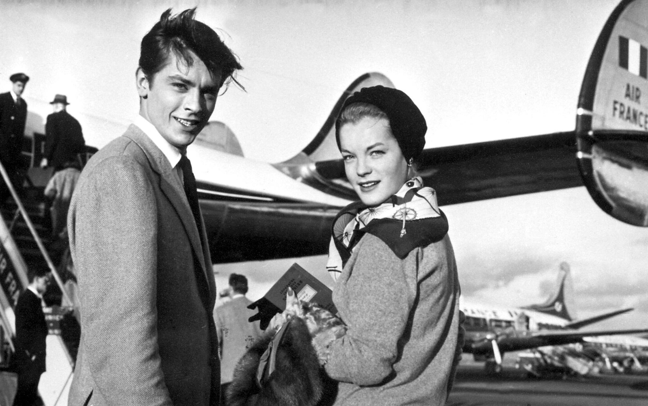 Alain Delon accompagné de l’actrice franco-allemande Romy Schneider en 1959 à l’aéroport d’Orly. (AFP) 