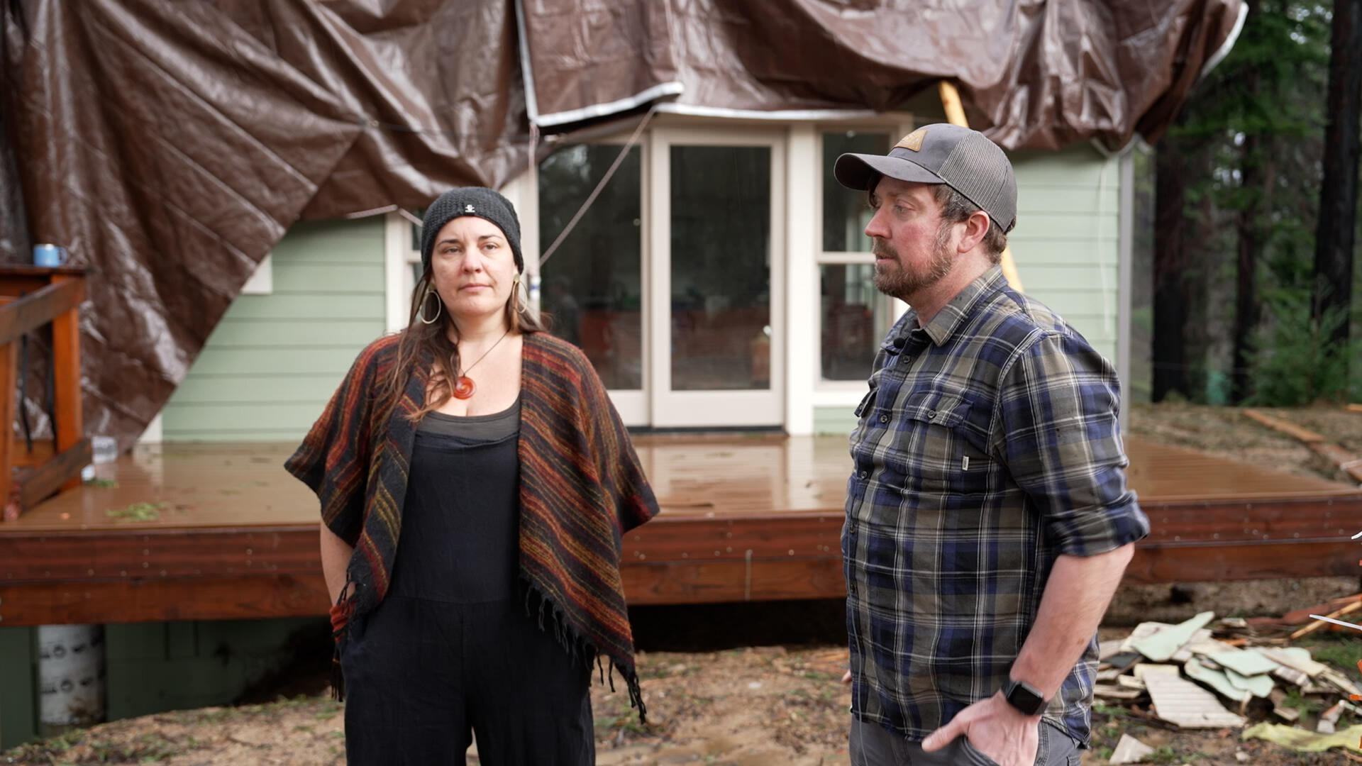 Jason y Shannon Phleger inspeccionan los daños en su propiedad después de las inundaciones y las fuertes lluvias en Boulder Creek, California