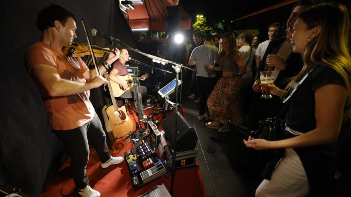 Music enthusiasts dance in front of a band in Paris street, as they take part in the French midsummer Festival of Music  "Fete de la Musique" marking its 40th anniversary.