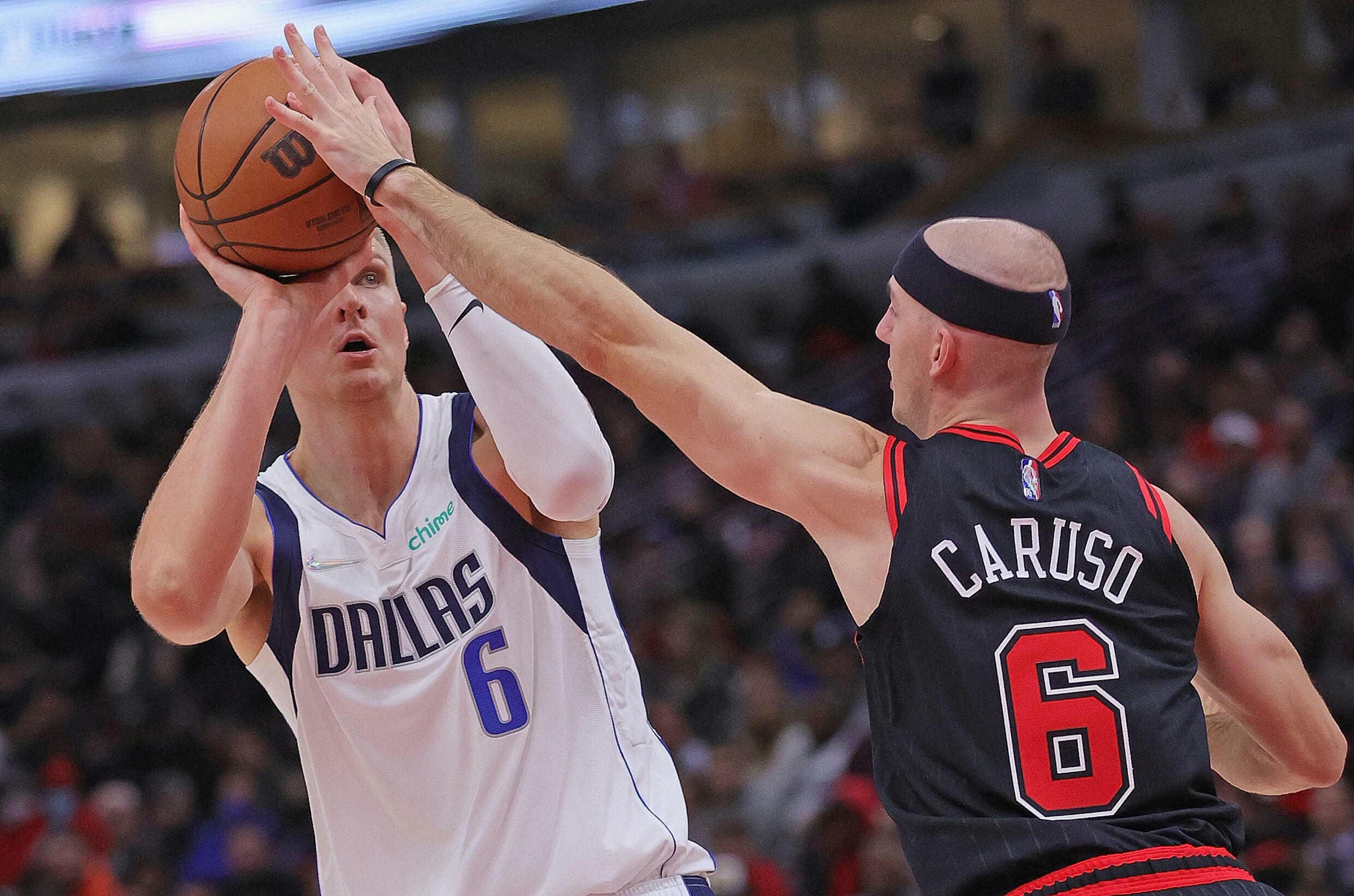 Kristaps Porzingis des Dallas Mavericks prépare un shoot, en face d'Alex Caruso des Chicago Bulls, le mercredi 10 novembre au United Center de Chicago, Illinois