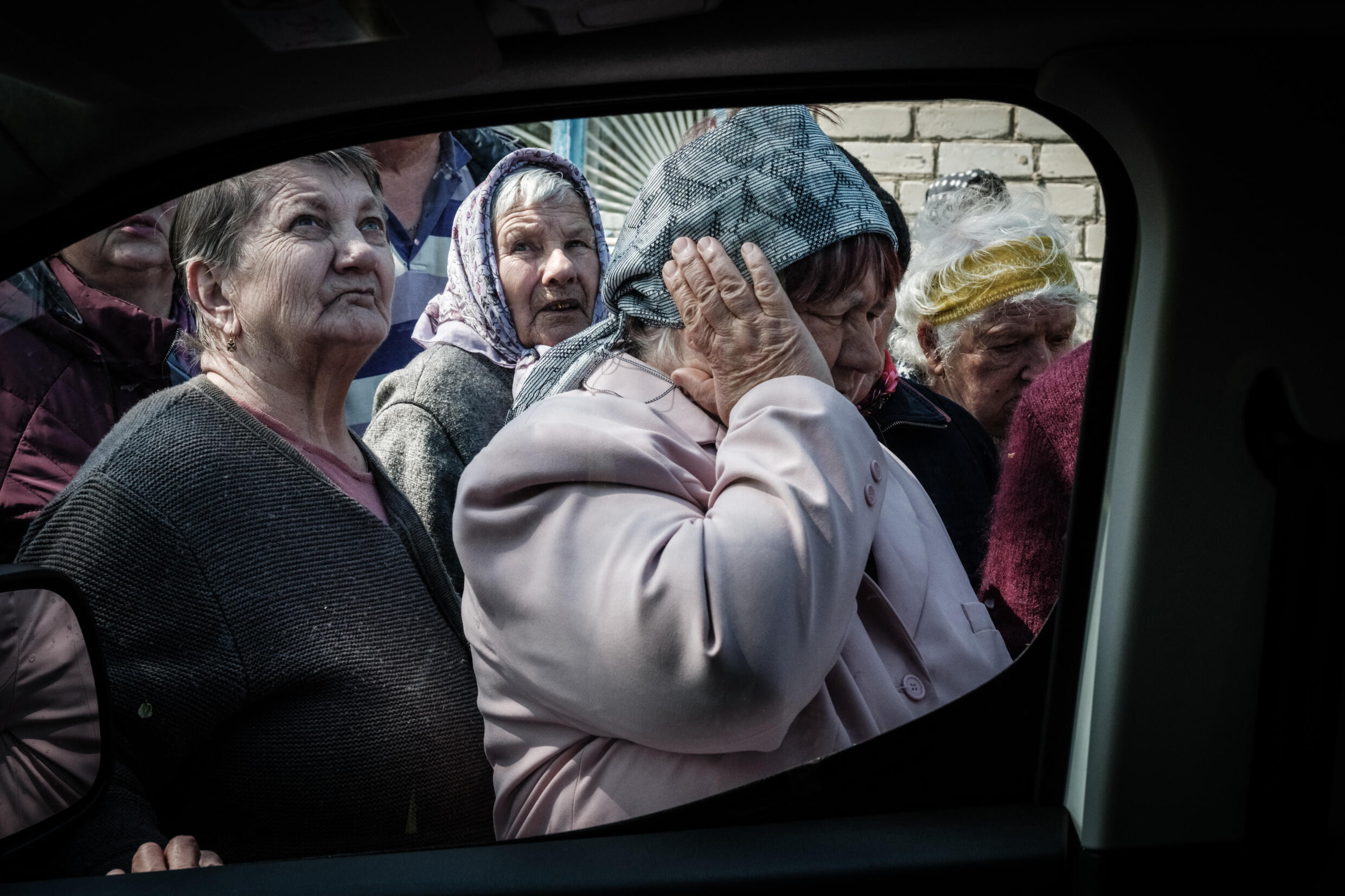 Some of the pensioners crowding around the cash delivery van covered their ears to mute the sounds of mortar fire