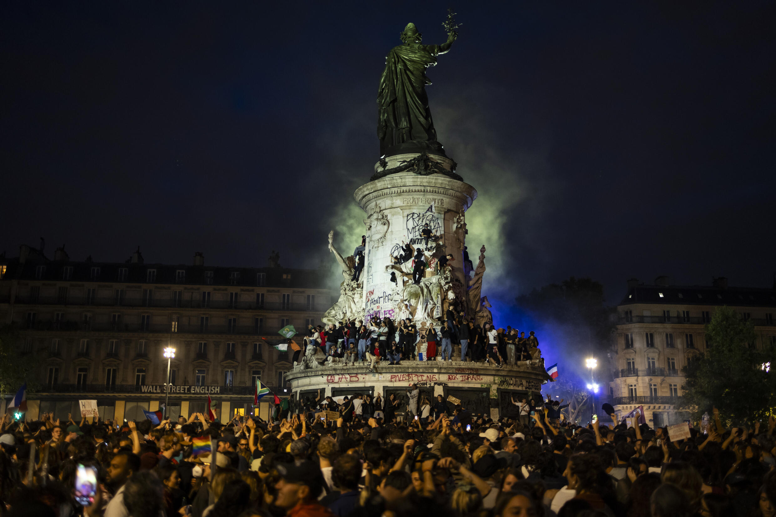 Une foule célèbre l'arrivée en tête surprise du Nouveau Front Populaire (NFP) au second tour des élections législatives, le 7 juillet 2024 place de la République à Paris