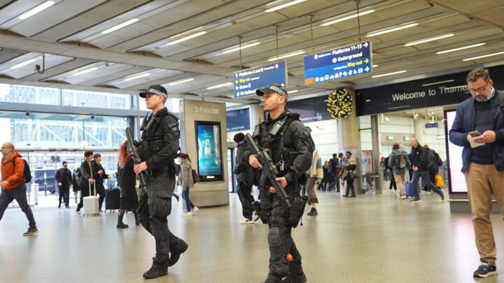 Armed police officers patrol St. Pancras International train station in London, England, on November 3, 2025.