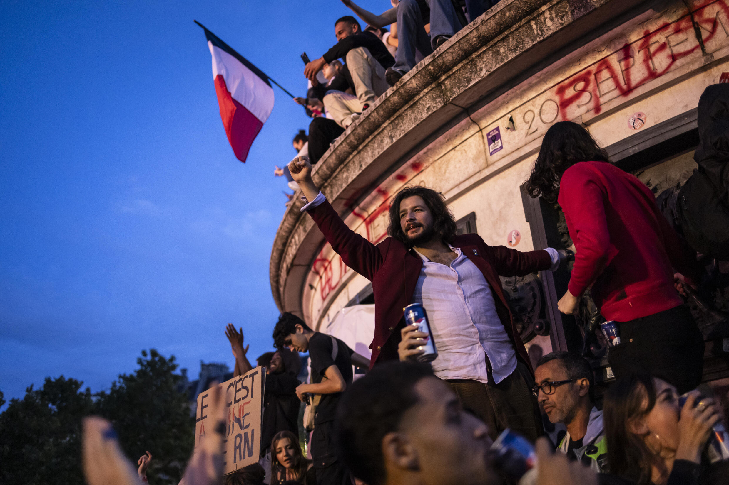 Une foule célèbre l'arrivée en tête surprise du Nouveau Front Populaire (NFP) au second tour des élections législatives, le 7 juillet 2024 place de la République à Paris