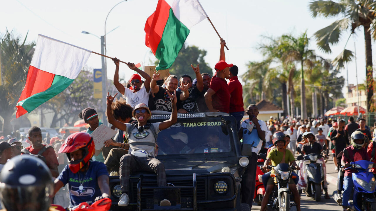 Des manifestants célèbrent en brandissant des drapeaux malgaches après que les militaires ont déclaré prendre le pouvoir après un vote de destitution du président Rajoelina, le 14 octobre 2025.