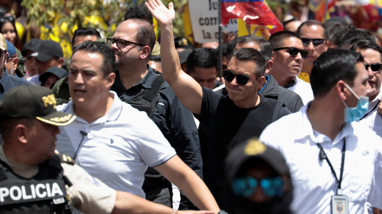 El presidente de Ecuador, Daniel Noboa, saluda mientras camina con el ministro del Interior, John Reinberg, durante una marcha de protesta después de que la Corte Constitucional del país suspendiera temporalmente partes clave de sus leyes de seguridad recientemente aprobadas por la legislatura, en Quito, Ecuador, el 12 de agosto de 2025.