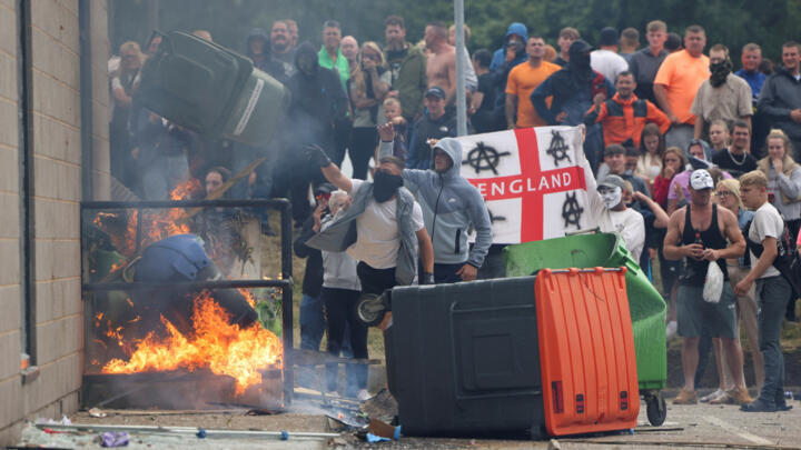 Manifestantes arrojan un contenedor de basura durante una protesta contra la inmigración en Rotherham, Reino Unido, el 4 de agosto de 2024.