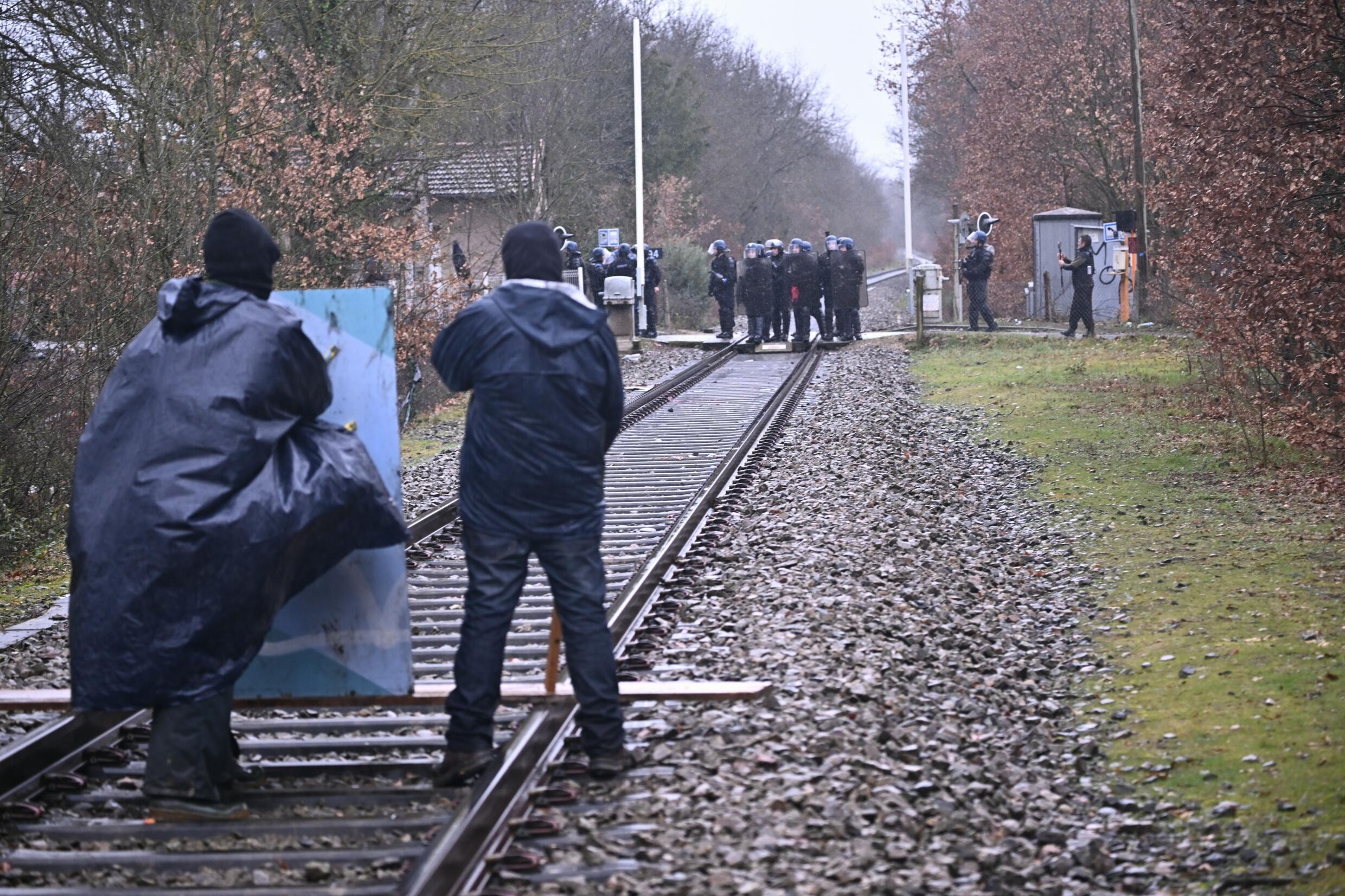 Des opposants à la construction de l'autoroute A69 font face aux gendarmes près du campement de la ZAD, le 10 février 2024 à Saïx, dans le Tarn.