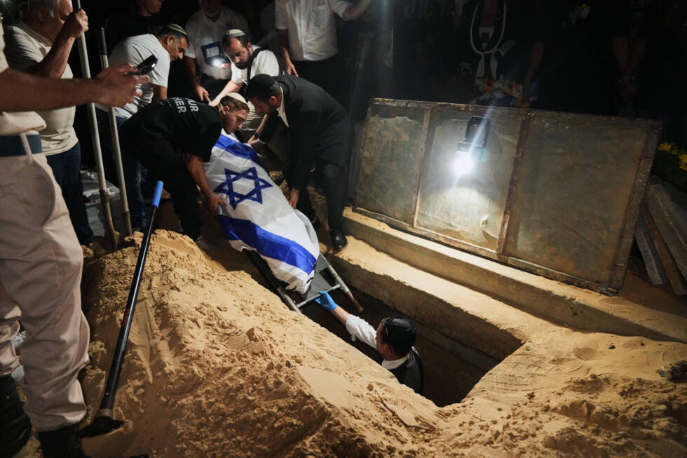 Relatives and friends lower the body of slain Israeli hostage Eitan Levi after his body was returned from Gaza at Bat Yam cemetery, Israel, October 16, 2025.