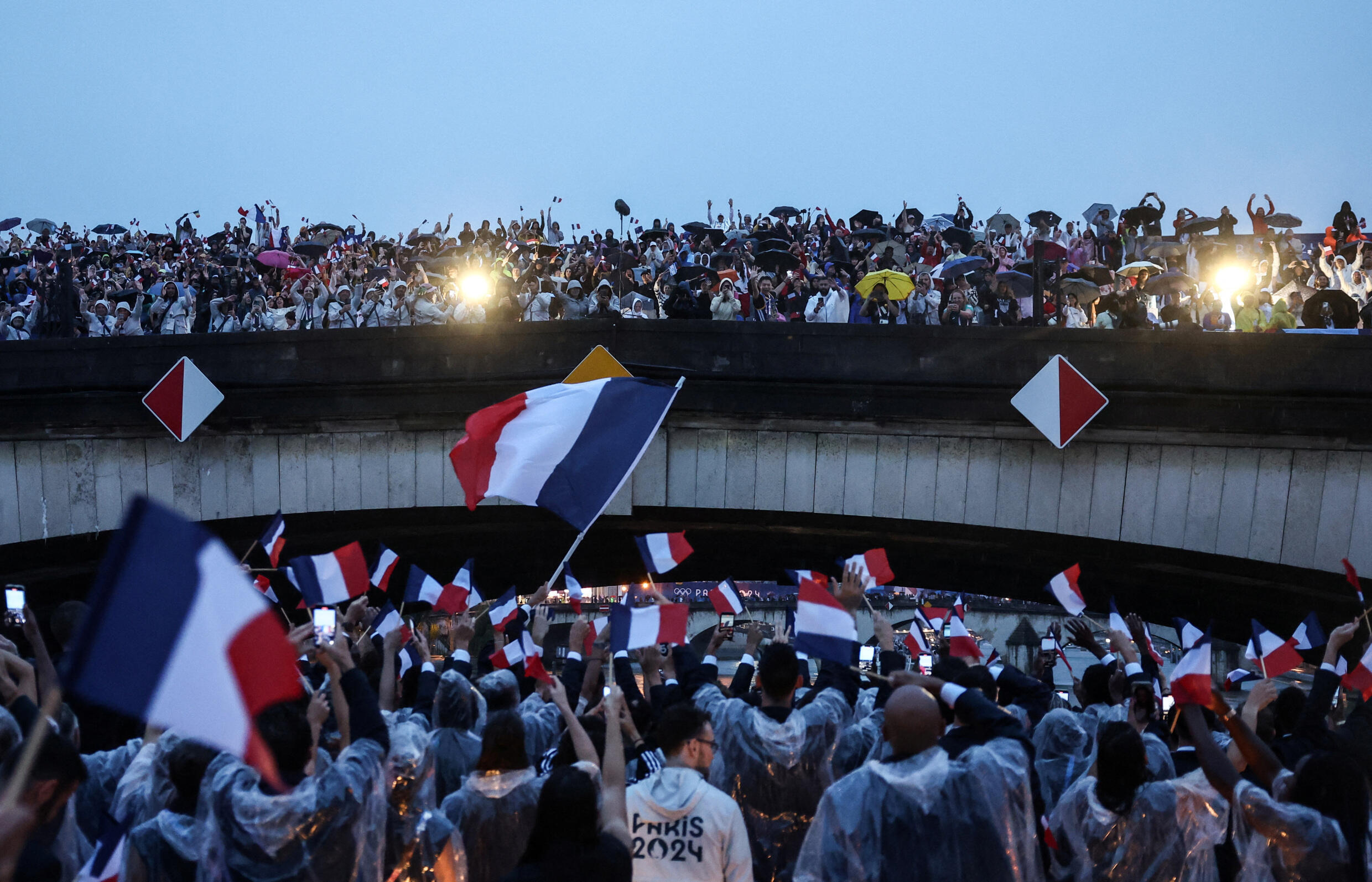 Les athlètes de la délégation française font leur entrée sur un bateau lors de la cérémonie d'ouverture des Jeux olympiques de Paris 2024.