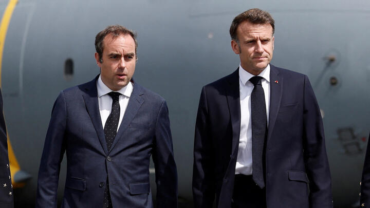 Prime Minister Sebastien Lecornu walks with French President Emmanuel Macron at the Le Bourget Airport in Paris on June 20, 2025.
