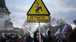 Ένας διαδηλωτής κρατά μια πινακίδα που γράφει "Σύνταξη υπό πίεση" κατά τη διάρκεια διαδήλωσης στην πλατεία Republique στο Παρίσι, 21 Μαρτίου 2023.