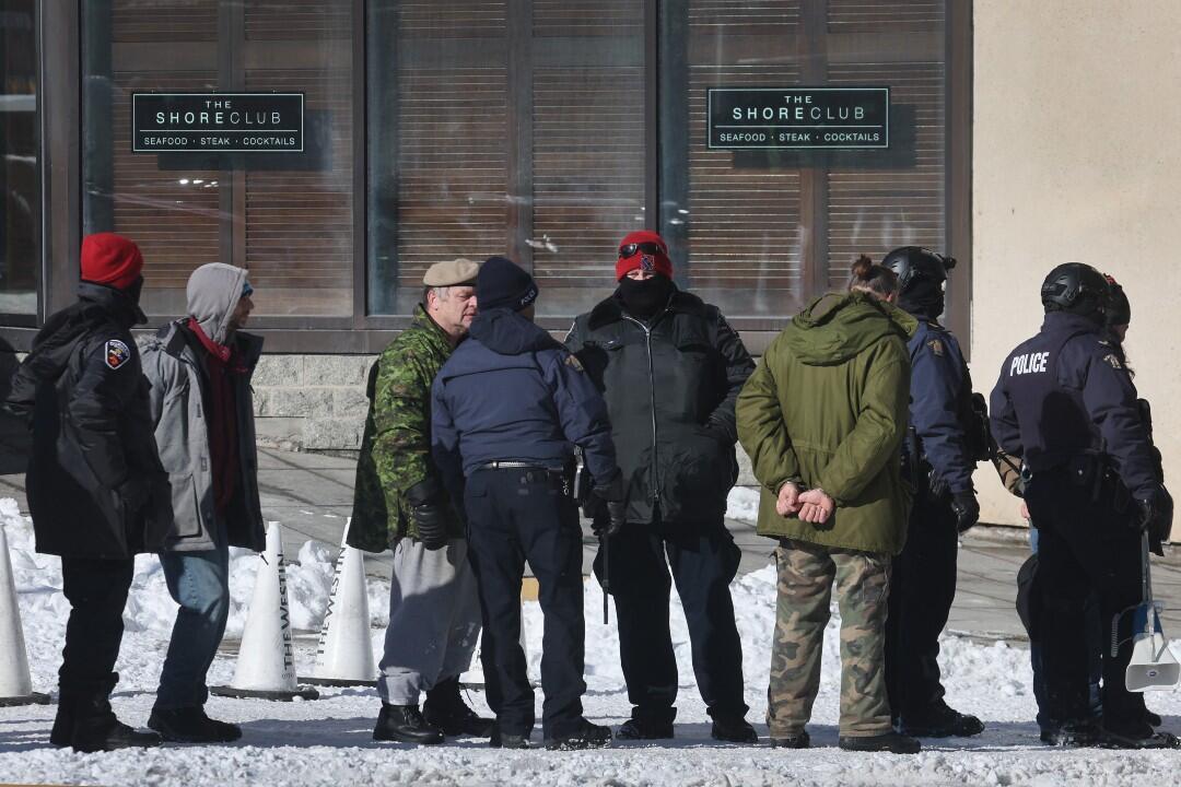 La policía se prepara para transportar a los detenidos mientras comienza a disolver una protesta organizada por camioneros que se oponen a los mandatos de vacunas el 18 de febrero de 2022 en Ottawa, Ontario, Canadá.