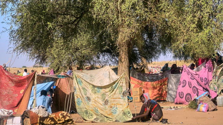 A Sudanese who fled el-Fasher city ties her tent at a camp in Tawila on November 2, 2025.