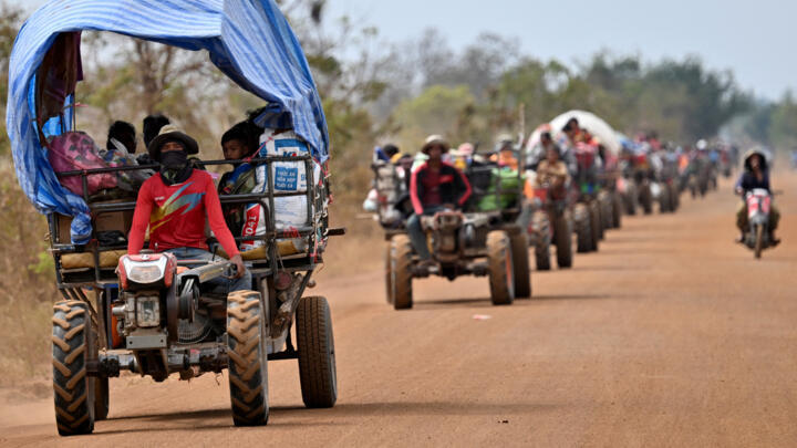 Displaced residents evacuate with their belongings along the Cambodia-Thailand border in Cambodia's Siem Reap province