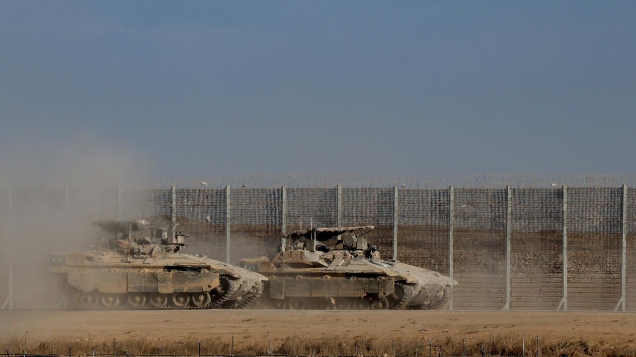 Israeli armoured personnel carrier (APC) vehicles manoeuvre along the border with Gaza on October 10, 2025.