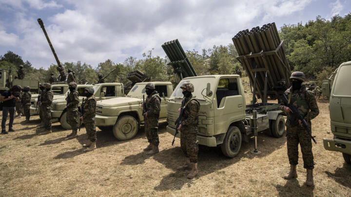 Fighters from the Lebanese militant group Hezbollah carry out a training exercise as they stand in front of launcher rockets trucks, in the Jezzine District, southern Lebanon, May 21, 2023. 