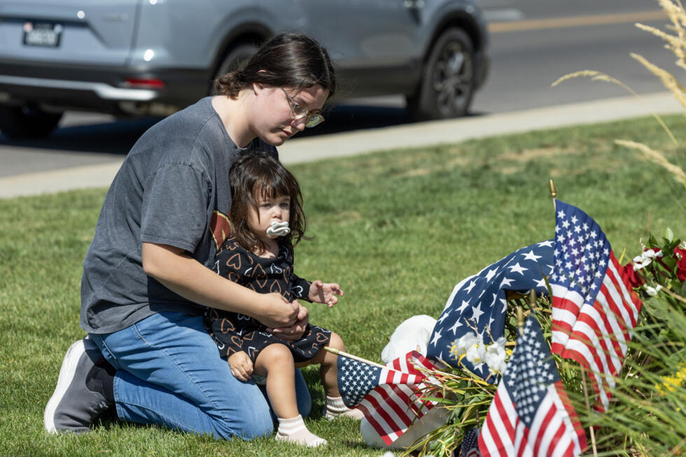 A woman pays tribute to Charlie Kirk at a memorial set up outside of Timpanogos Regional Hospital in Orem.