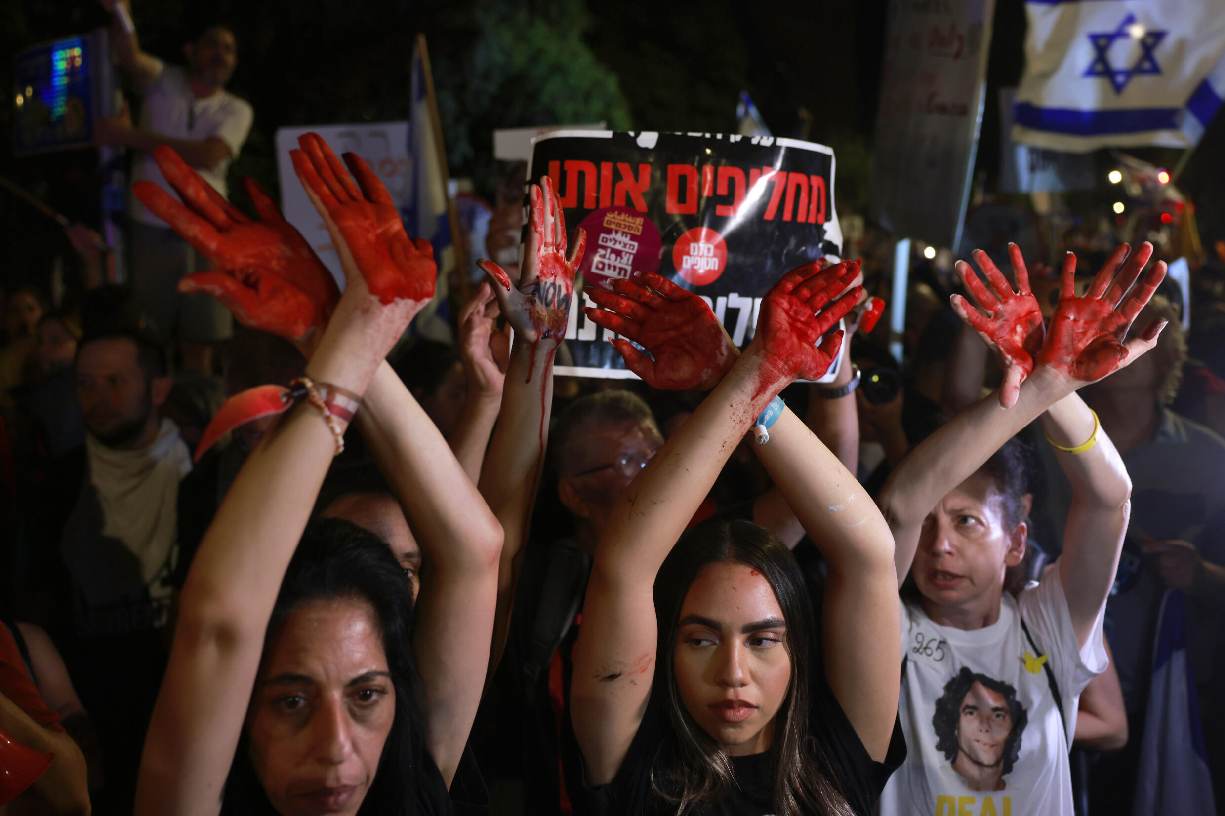 Des Israéliennes aux mains couvertes de peinture rouge symbolisant le sang participent à une manifestation près de la résidence du Premier ministre Benjamin Netanyahu à Jérusalem, appelant à des élections anticipées et à la libération des otages détenus à Gaza, le 27 juin 2024