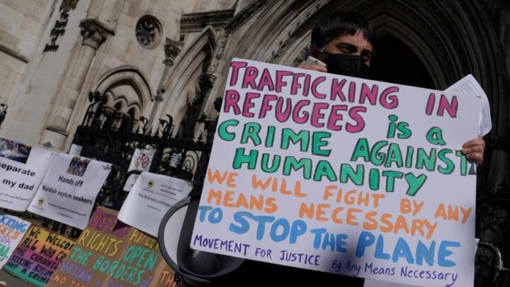 متظاهر ضد ترحيل المهاجرين إلى رواندا أمام المحكمة العليا في لندن في 13 يونيو/حزيران 2022.