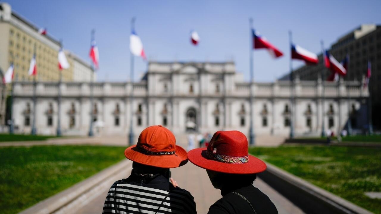 Dos mujeres observan el Palacio de La Moneda, la casa de gobierno de Chile, en Santiago, el 9 de octubre de 2025.