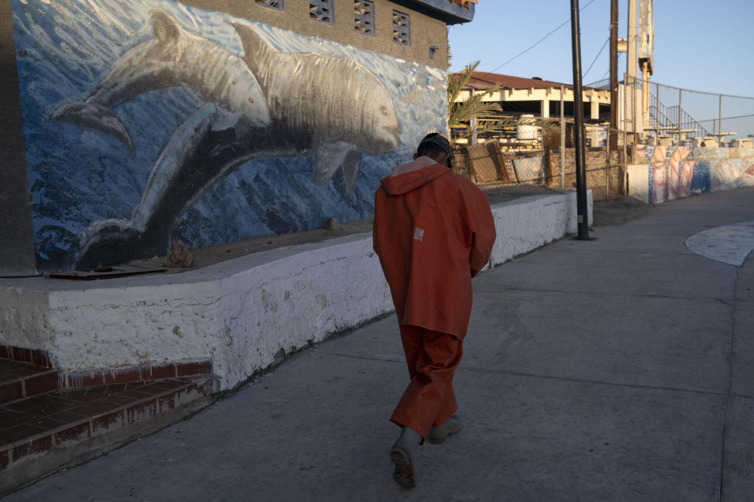 Un pescador camina cerca del mural de los Wakita Borbois en San Felipe, en el noroeste de México.