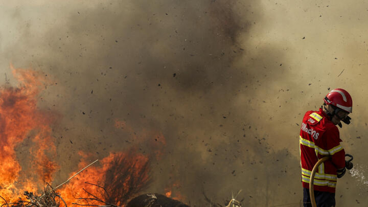 Firefighters battle a wildfire in Trancoso on August 11, 2025.