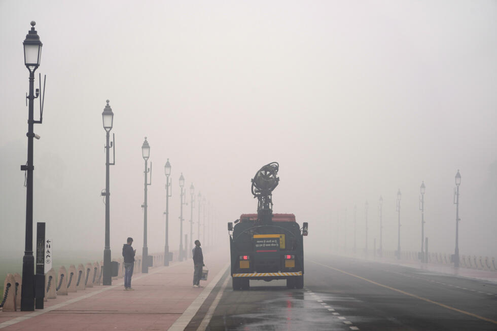 A Delhi government vehicle sprinkles water to control air pollution amidst thick Layer of smog in New Delhi, India, Monday, Nov. 18, 2024.
