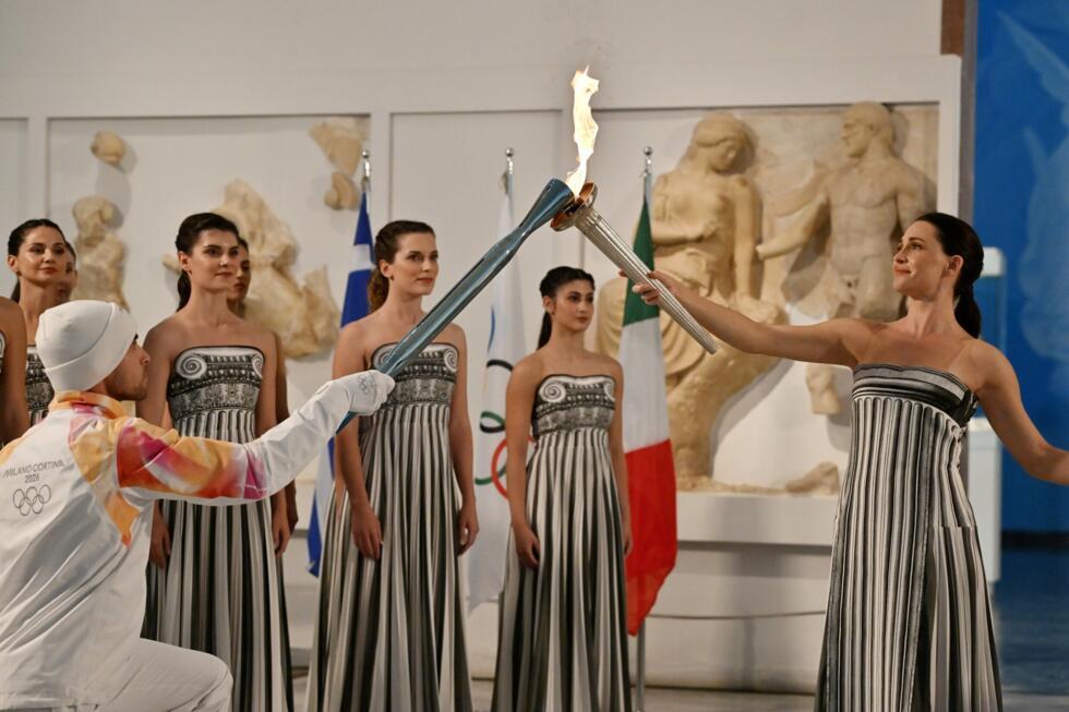 Greek actress Mary Mina (R), playing the role of the High Priestess, passed the Olympic flame to Greek rower Petros Gaidatzis