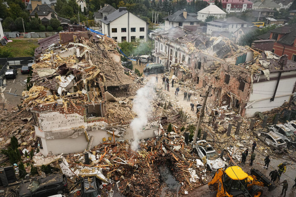 Rescuers work at the site of an apartment buildings damaged during a Russian attack in Kyiv, Ukraine, Sunday, September 28, 2025.