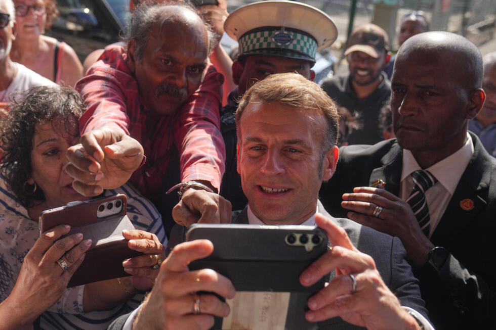 Emmanuel Macron maakt op 20 november 2025 een selfie met burgers tijdens zijn bezoek aan het Caudan Arts Centre op Mauritius tijdens zijn rondreis door Afrika.