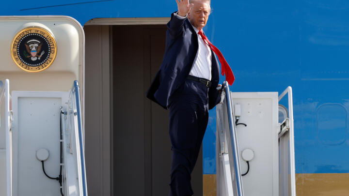 US President Donald Trump waves from the stairs of Air Force One as he boards upon his arrival at Joint Base Andrews, Maryland., Friday, Oct. 31, 2025.
