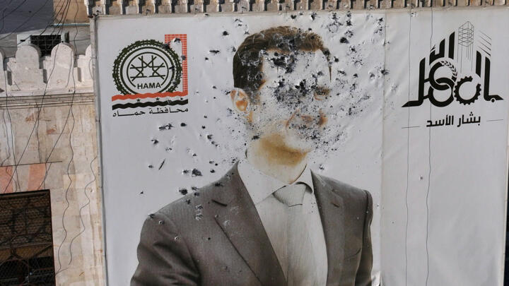 A bullet-riddled portrait of Syria's Bashar al-Assad adorns Hama's municipality following the city's capture by rebel forces on December 6, 2024.