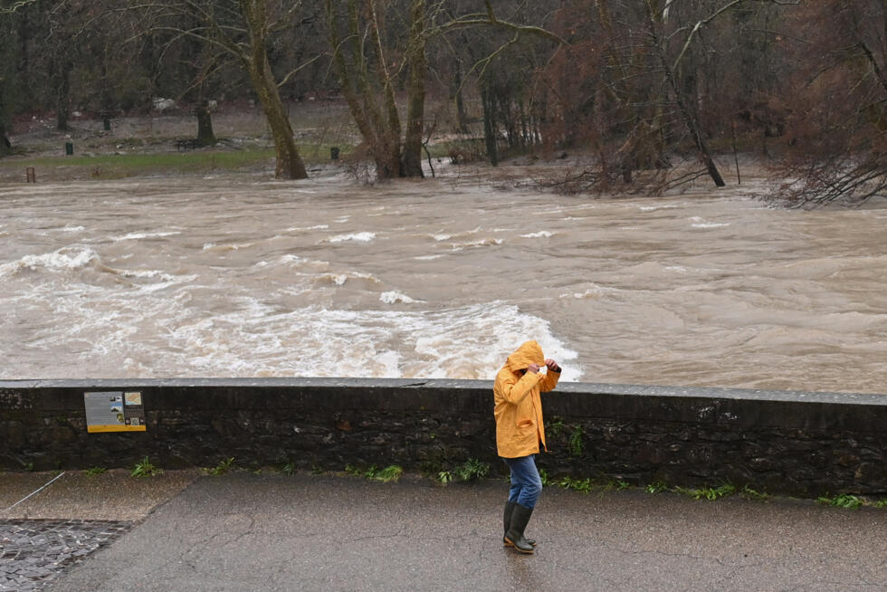 Un passant sur les berges de l'Hérault, qui a débordé suite aux fortes pluies à Laroque, le 22 décembre 2025