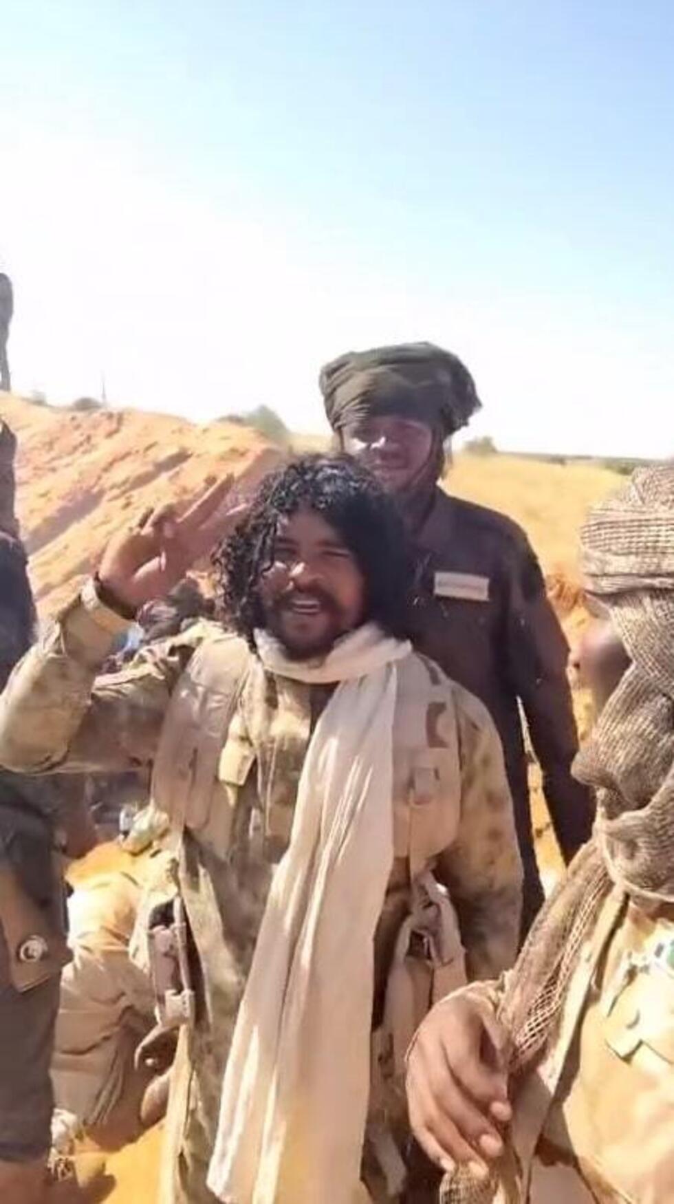 This screengrab taken from one of the videos posted on Telegram on October 27, 2025, shows Abu Lulu striking a pose in front of a mass grave.