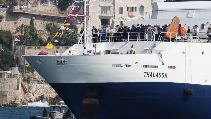 France's President Emmanuel Macron and his wife Brigitte Macron (C) stand atop the deck of French research vessel "Thalassa" as it arrives from Monaco to Nice, on June 8, 2025.